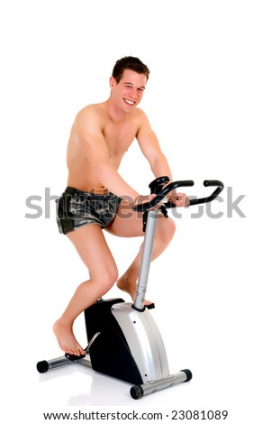Young attractive male body builder on fitness bike, bicycle. Studio shot, white background.