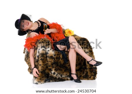 Attractive young drunk glamor lady in arm chair with classy hat and red boa, evening dress.  Studio shot, white background.