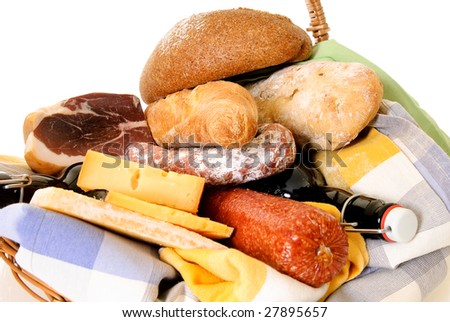 Wicker food basket with cheese, bread, beer and meat. Studio shot. Focus on bread in back.