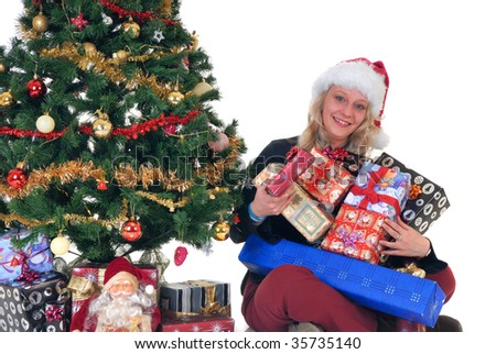 Smiling teenage girl next to Xmas, Christmas three with hands full of presents, gifts, Santa puppet in front.  White background.
