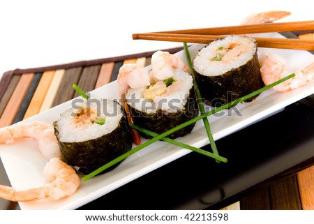 Plate with traditional Japanese sushi, sashimi rolls.  Shop sticks on the side.  Studio shot.