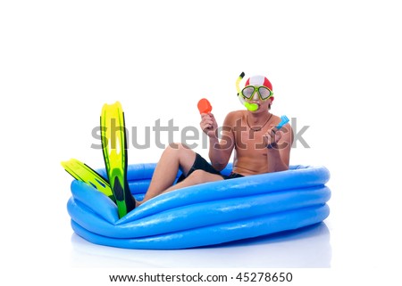First swimming lessons for dummies, young man with snorkel, goggles and flippers.  Humorous studio shot.