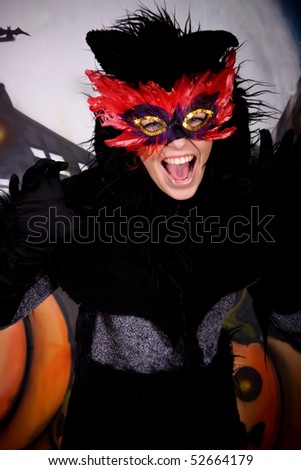 Halloween character, female cat costume.    Studio shot, painted themed background.
