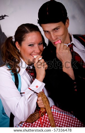 Young Halloween couple, female  and male with English boarding school student outfit.    Studio shot, painted background.