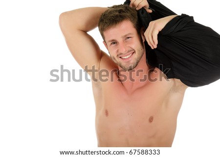 stock photo Young and sexy caucasian man undressing Takes tshirt off