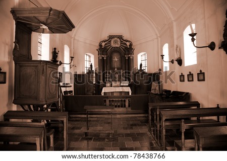 Interior shot of an old vintage rural Belgium church in sepia colors.