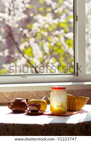 breakfast on the sunny kitchen on spring (tea, honey, sugar, fruits)