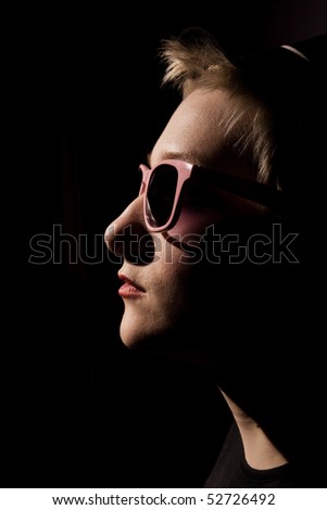 rock star in the dark in pink glasses in the profile