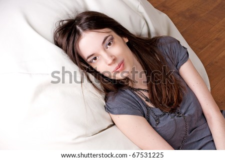 beauty young woman with brown eyes lies on a pillow