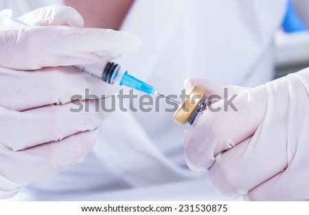The doctor gains the medicine in the syringe. Hands closeup