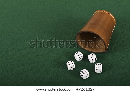 Dices and a dice box on green felt
