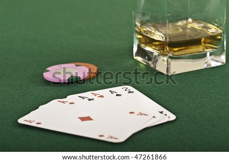 Four aces, chips and a drink in detail