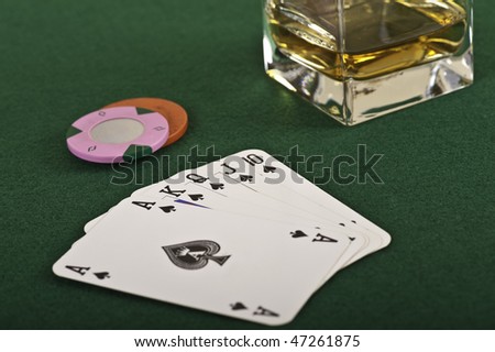Royal flush, chips and a drink in detail