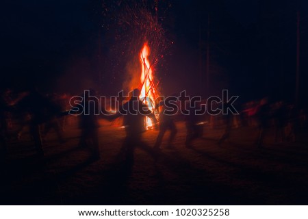 Huge fire at night and young people around. Pagan festival of Walpurgis night: bonfires, dancing wildly, demons, witches. Folk festival, popular holiday. German legends, St. Walburgas, Satanism, devil