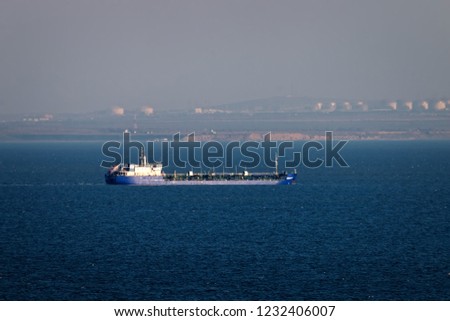 Shipping in Kerch Strait of Black sea of Azov sea. Oil tanker river-sea and huge tanks with fuel on shore (Taman), ship traffic, cabotage. Marine transportation of petroleum products, oil terminal
