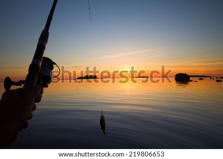 Sunset river perch fishing with the boat and a rod