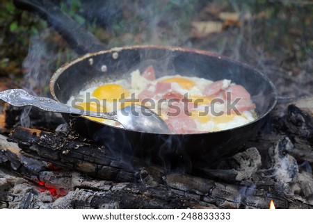 Removed  process of a eggs with sausages on  coals. Shooting closeups