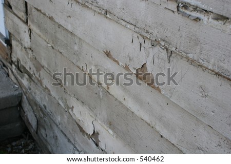 Peeling paint on exposed house after siding is pulled off