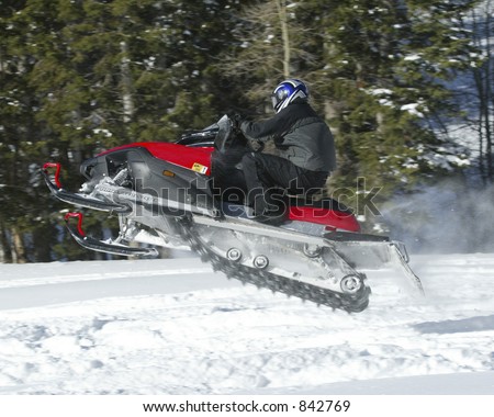 red snowmobile turning away in the air