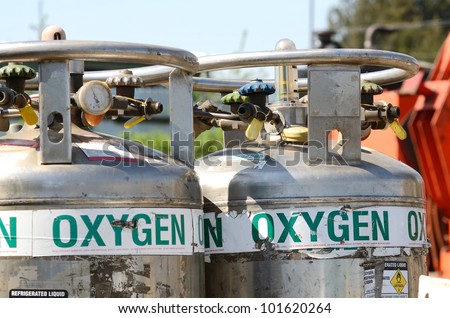 Two large liquid oxygen tanks at the ready in a metal recycling yard