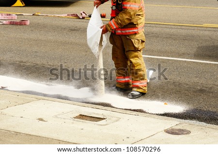 Fire fighters spreading absorbant at a four vehicle accident involving two large trucks resulted in a single injury and a diesel fuel spill. July 17, 2012 in Roseburg Oregon