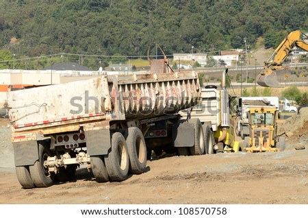 Dump truck at a large construction site removing a hill during an airport runway expansion project
