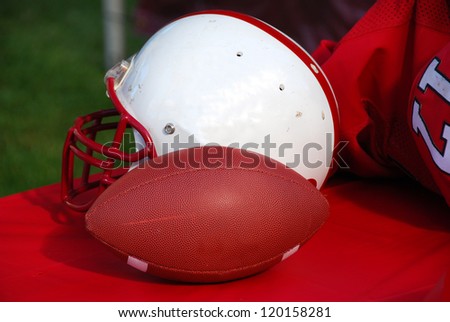 Football helmet and pads on the bench