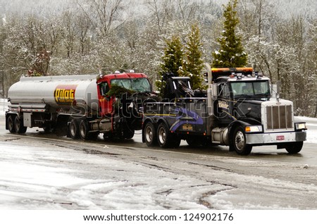 CANYONVILLE OR, USA - JANUARY 10: A tow truck hauls a truck and trailer away following a fatal single vehicle accident during a recent snow storm, on I-5 near Canyonville Oregon, January 10, 2013