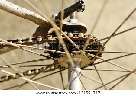 The worn gears and chains on the back of a bicycle wheel
