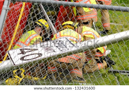 ROSEBURG, OR - MARCH 19: Emergency workers extricate a victim from a single car, rollover accident during a spring rain in Roseburg Oregon, March 19, 2013