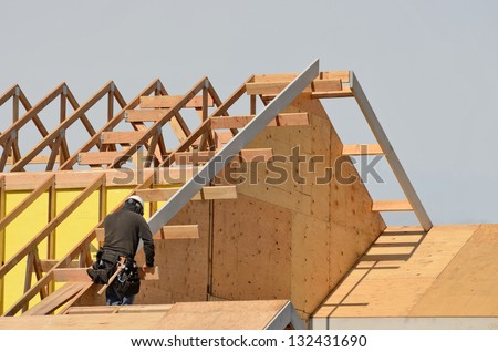 Construction crew working on the roof sheeting and fascia of a new, two story, commercial apartment building in Oregon