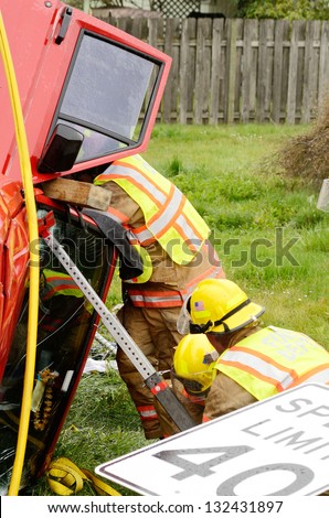 Emergency workers extricate a victim from a single car, rollover accident during a spring rain in Roseburg Oregon, March 19, 2013