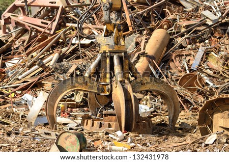 Large magnet attached to a track hoe excavator at a metal recycling plant