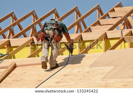 Construction Crew Working On The Roof Sheeting Of A New, Two Story, Commercial Apartment Building In Oregon