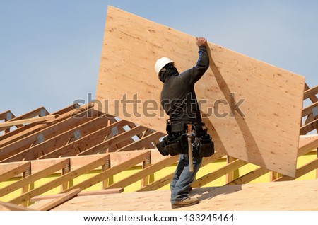 Construction crew working on the roof sheeting of a new, two story, commercial apartment building in Oregon