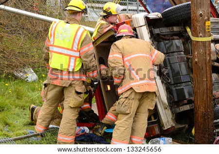 ROSEBURG, OR - MARCH 2013: Emergency workers at the scene of a single car, rollover accident during a spring rain in Roseburg Oregon, March 19, 2013