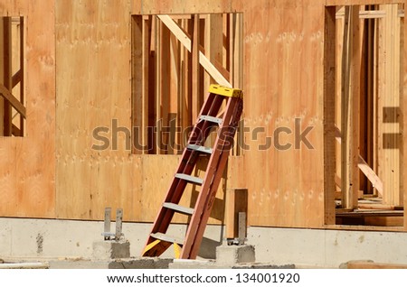 Small ladder leans against a newly constructed wall at a commercial residential development building
