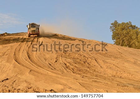 Large articulated dump truck moving dirt at a new commercial development construction project.