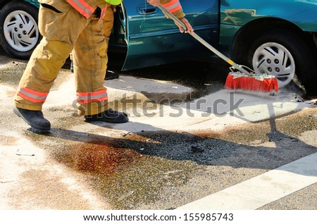 Fire fighters clean up spilled fluids at a two vehicle head on accident at an intersection in Roseburg, OR on August 27, 2013