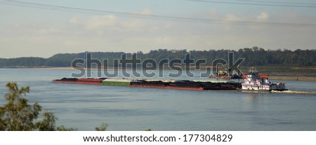 Tug boat and barges of petroleum oil passes under the Vicksburg Bridge along the Mississippi River