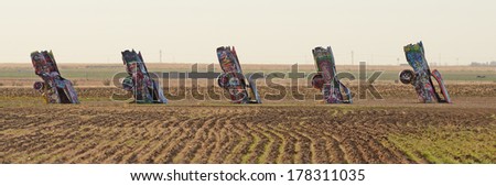 AMARILLO, TEXAS, USA - NOVEMBER 19, 2013: Cadillac Ranch is a public art sculpture of ten Cadillacs buried nose-down in a farm field in northeastern Texas