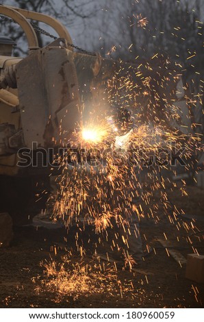 A mechanic welder uses a plasma cutter to cut metal plates from the blade of a bulldozer on a construction project