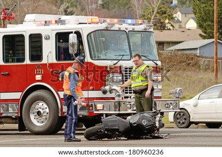 ROSEBURG, OR, USA - JANUARY 13, 2014:  Emergency responders at the scene of a motorcycle vs car at a busy intersection that left the rider with serious injuries.