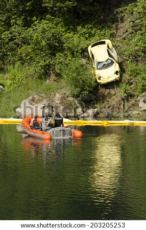 ROSEBURG, USA, USA - JUNE 02, 2014: Recovery of a small car that went into the Umpqua River after the driver was distracted.  The teen female driver escaped and received minor injuries