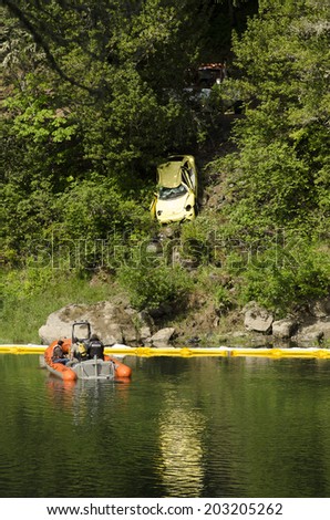 ROSEBURG, USA, USA - JUNE 02, 2014: Recovery of a small car that went into the Umpqua River after the driver was distracted.  The teen female driver escaped and received minor injuries