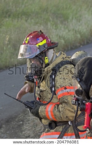 ROSEBURG, OR, USA - JUNE 10, 2014:  Firefighters respond to a single family home fire on a hot summer day in Roseburg, OR, USA on June 10, 2014