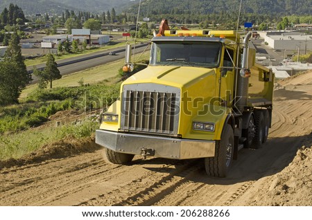 dump truck moving rock and dirt at a new commercial construction development project