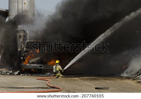 GUSTINE, CA, USA - JUNE 18, 2014: Fire fighters respond to a semi truck and silage fire at a dairy farm in Gustine, CA, on June 18, 2014