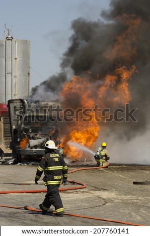 GUSTINE, CA, USA - JUNE 18, 2014: Fire fighters respond to a semi truck and silage fire at a dairy farm in Gustine, CA, on June 18, 2014