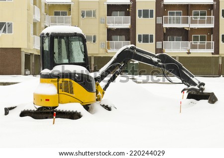 Building construction equipment sit idle during a winter snow and freezing rain storm